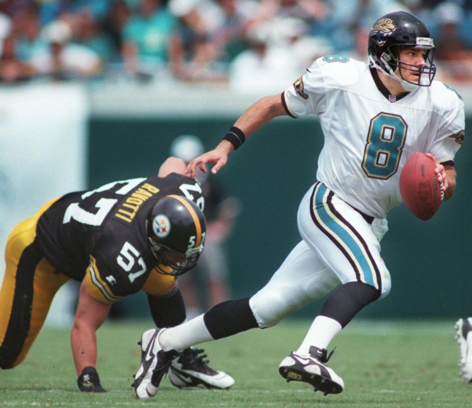 Jacksonville Jaguars quarterback Mark Brunell (8) scrambles away from Pittsburgh Steelers linebacker Eric Ravotti (57) during the first quarter of an NFL game on September 1, 1996. [Rick Wilson/Florida Times-Union]