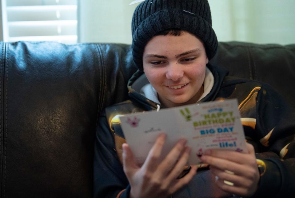 Tre Cardwell reads an early 14th birthday card at home Friday afternoon, Jan. 20, 2023. A group of friends at Poseyville High School had sent him a pile of cards and presents.