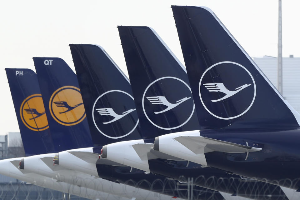 German Lufthansa planes sit parked in a line at the airport in Munich, Germany, Thursday, March 26, 2020. The planes are not in use because of the novel coronavirus outbreak. The new coronavirus causes mild or moderate symptoms for most people, but for some, especially older adults and people with existing health problems, it can cause more severe illness or death. (AP Photo/Matthias Schrader)