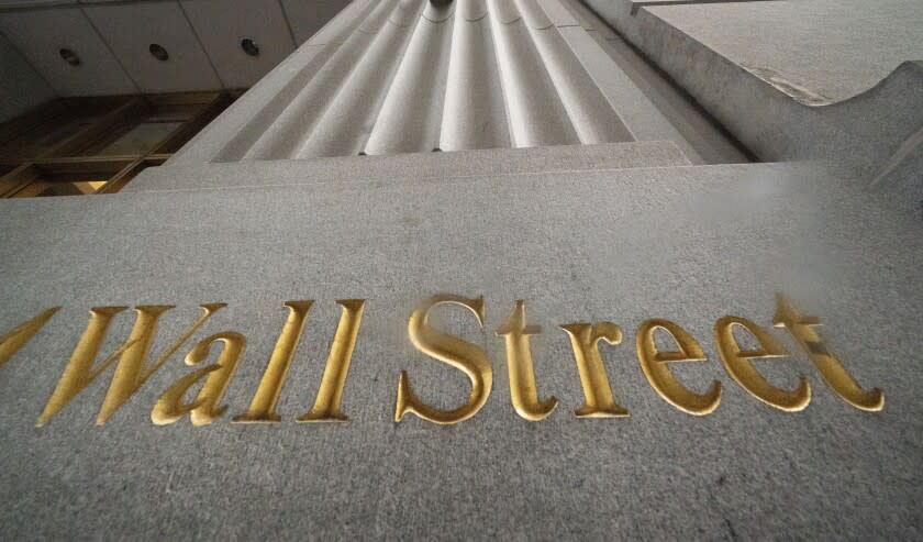 FILE - In this Nov. 5, 2020 file photo, a sign for Wall Street is carved in the side of a building, in New York. Stocks are opening broadly higher on Wall Street Monday, Sept. 13, 2021, as the market regains a more solid footing following its biggest weekly drop since June. (AP Photo/Mark Lennihan, File)