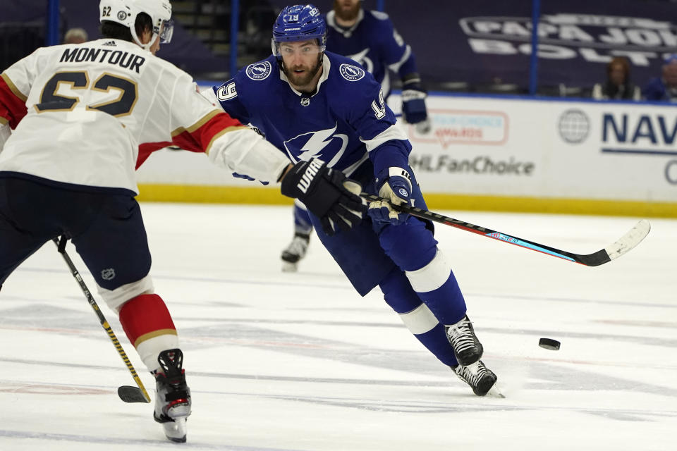 Tampa Bay Lightning right wing Barclay Goodrow (19) dumps the puck past Florida Panthers defenseman Brandon Montour (62) during the second period in Game 6 of an NHL hockey Stanley Cup first-round playoff series Wednesday, May 26, 2021, in Tampa, Fla. (AP Photo/Chris O'Meara)