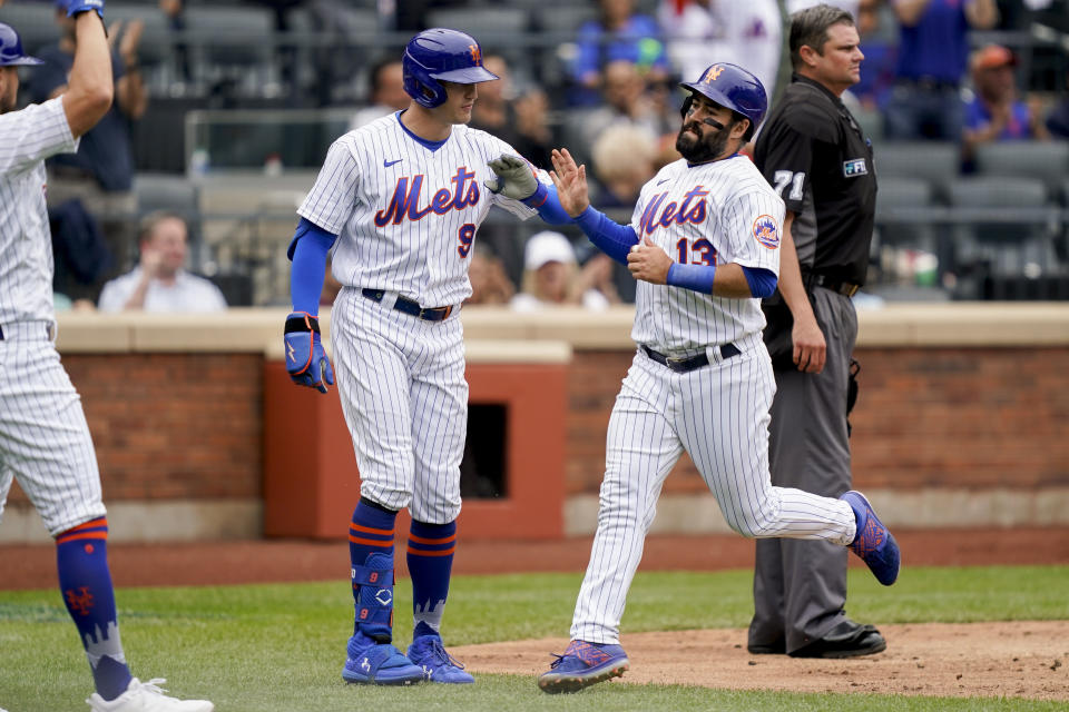 New York Mets' Luis Guillorme (13) celebrates with Brandon Nimmo (9) after scoring on a two-run double hit by Tomas Nido off Washington Nationals starting pitcher Evan Lee (59) in the fourth inning of a baseball game, Wednesday, June 1, 2022, in New York. (AP Photo/John Minchillo)