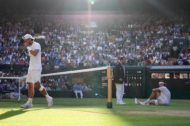 The Umpire checks on Taylor Fritz as Lorenzo Musetti walks away