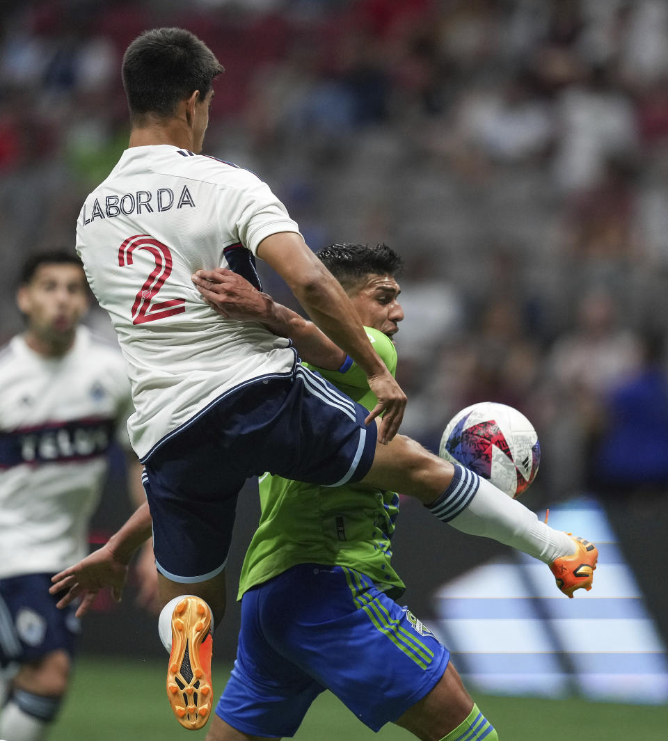 Vancouver Whitecaps' Mathias Laborda (2) and Seattle Sounders' Xavier Arreaga vie for the ball during the second half of an MLS soccer match in Vancouver, British Columbia on Saturday, May 20, 2023. (Darryl Dyck/The Canadian Press via AP)