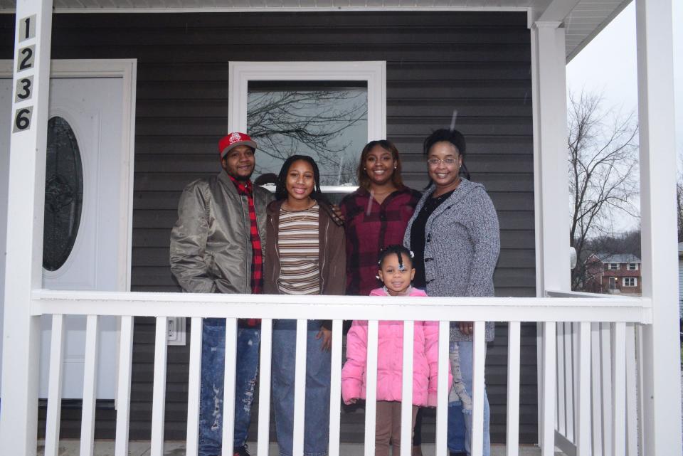 The Williams Family, from left, Lawrence, La'Kasia, La'Kayla, La'Khi and Kelly, stand on the porch of their new home at 1236 Noble St. in Alliance after receiving the keys to the Apostle Build home on Sunday, Dec. 17, 2023.