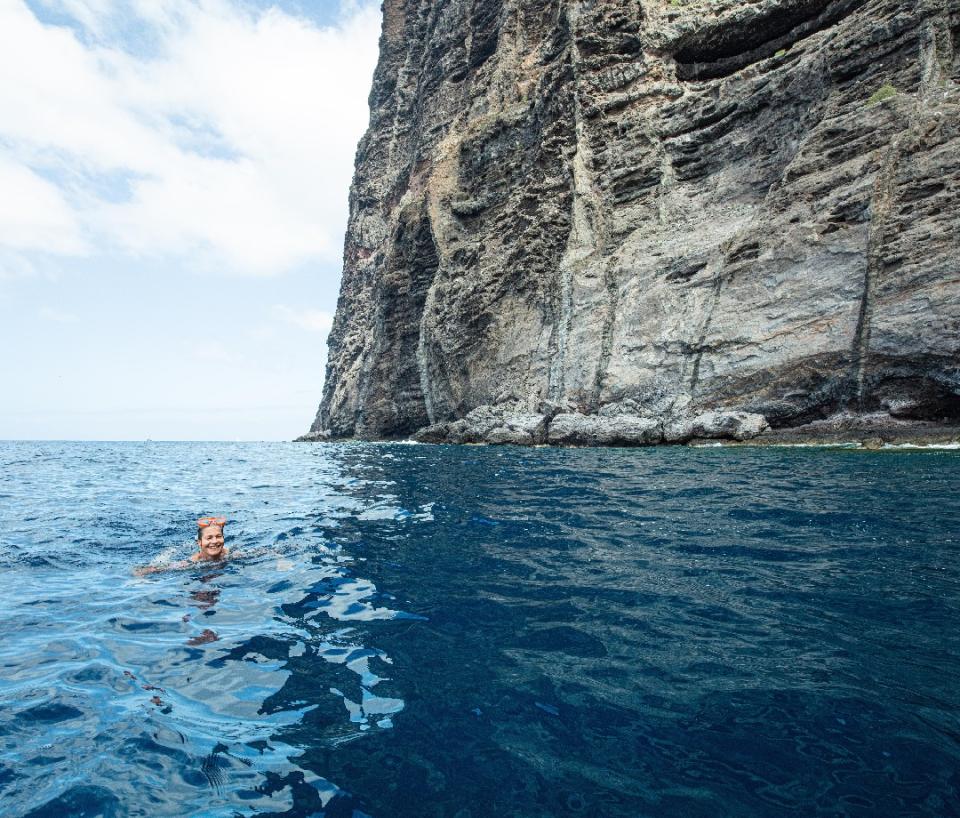 Woman swimming by the cliffs of Tenerife.