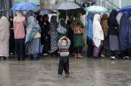 Afghan women stand in line as they wait to vote at a polling station in Kabul April 5, 2014. REUTERS/Mohammad Ismail