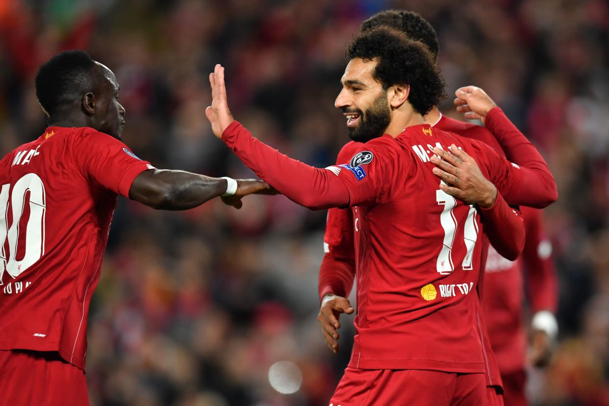 Liverpool's Egyptian midfielder Mohamed Salah (R) celebrates with Liverpool's Senegalese striker Sadio Mane (L) and Liverpool's Brazilian midfielder Roberto Firmino after scoring their fourth goal during the UEFA Champions league Group E football match between Liverpool and Salzburg at Anfield in Liverpool, north west England on October 2, 2019. (Photo by Paul ELLIS / AFP) (Photo by PAUL ELLIS/AFP via Getty Images)