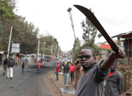 A supporter of opposition leader Raila Odinga gestures with a machete in Kibera slum in Nairobi, Kenya, August 11, 2017. REUTERS/Goran Tomasevic
