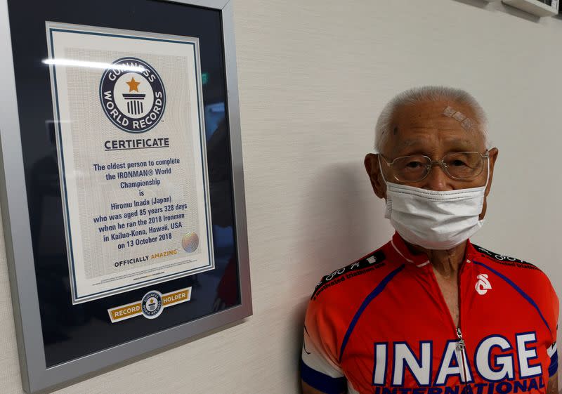 iromu Inada, redord holder of the oldest person to complete an Ironman World Championship, poses for a photograph next to his certificate from Guinness World Record in Chiba, Japan