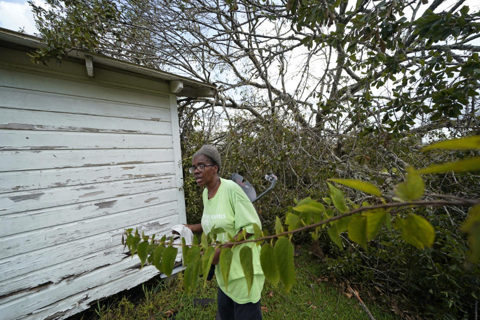 Wyna Dennis shows the damage to her home from fallen trees before she leaves Lake Charles, La., in the aftermath of Hurricane Laura, Sunday, Aug. 30, 2020. (AP Photo/Gerald Herbert)