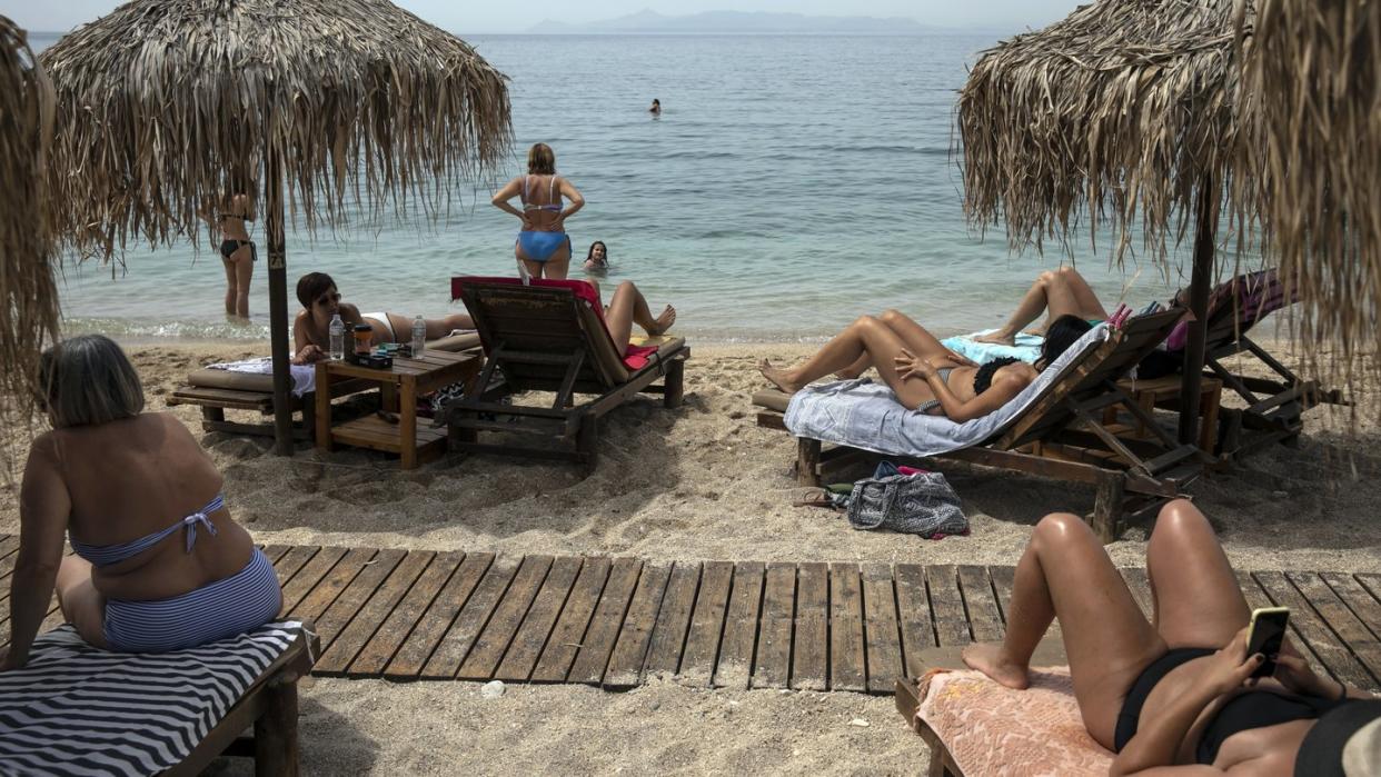 Urlauber liegen am Strand von Alimos (Griechenland).