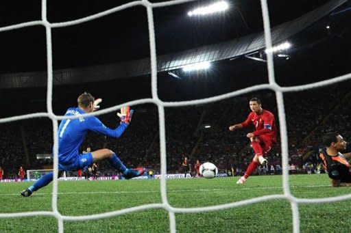 Portuguese forward Cristiano Ronaldo (C) scores past Dutch goalkeeper Maarten Stekelenburg in his second goal of the night during the Euro 2012 football championships match Portugal vs. Netherlands at the Metalist stadium in Kharkiv. A double from Ronaldo inspired Portugal to a 2-1 victory over Holland in their Euro 2012 Group B match, sending the 2010 World Cup finalists out of the tournament