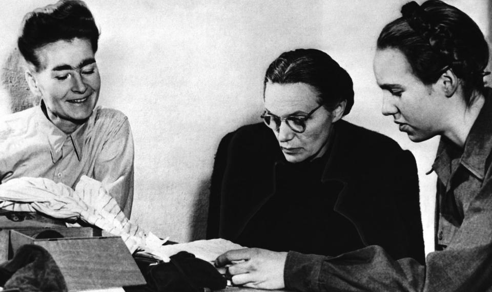 FILE - The Jan 1, 1946 file photo shows Margarete Himmler, wife of the German S.S. Chief who committed suicide, centre, as she reads over some papers with her daughter Gudrun, right, as they are watched by Louise Cuyon-Witzschel, who was secretary at the S.S. Headquarters in Italy, at Nuremberg, Germany, where they are waiting to testify in the trial of Major Nazi War Criminals. German newspaper Welt am Sonntag has published a trove of letters believed to be written by Nazi SS leader Heinrich Himmler. On seven full pages the paper on Sunday Jan. 26,2014 showed pictures of Himmler and his family smiling into the camera during a fishing trip, the top Nazi taking a bath in a lake or feeding a little fawn. Welt said it worked together with Israeli film director Vanessa Lapa, whose family had the documents in its possession. (AP Photo,File)