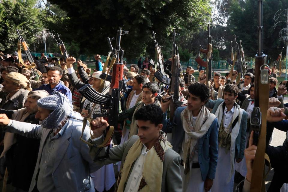 Newly-recruited Houthi fighters hold up weapons during a protest against the US-UK air strikes, in Sana’a, Yemen (EPA)