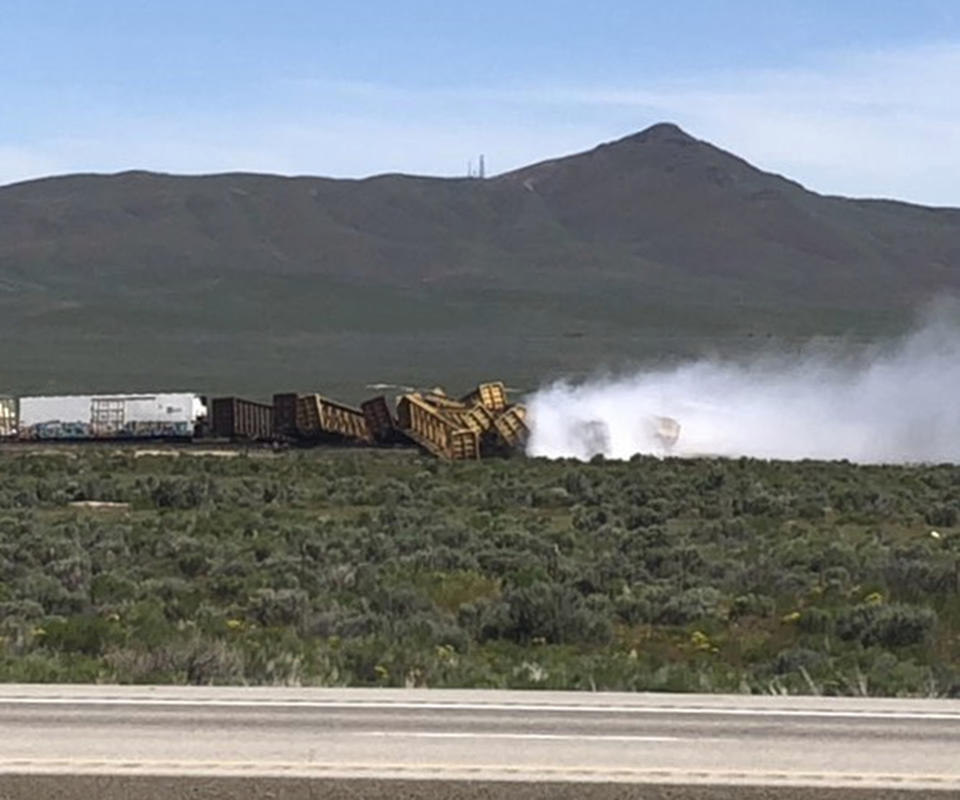 In this photo provided by Michael Lyday shows a train derailment and potential hazardous materials spill east of Wells, Nev., Wednesday, June 19, 2019. A 60-mile stretch (96 kilometers) of U.S. Interstate 80 in northeast Nevada has been closed while emergency crews respond to the train derailment and potential hazardous materials spill east of Wells. (Michael Lyday via AP)