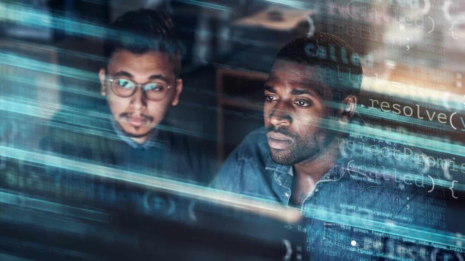 Concept of two young professional men looking at screen in technical data center