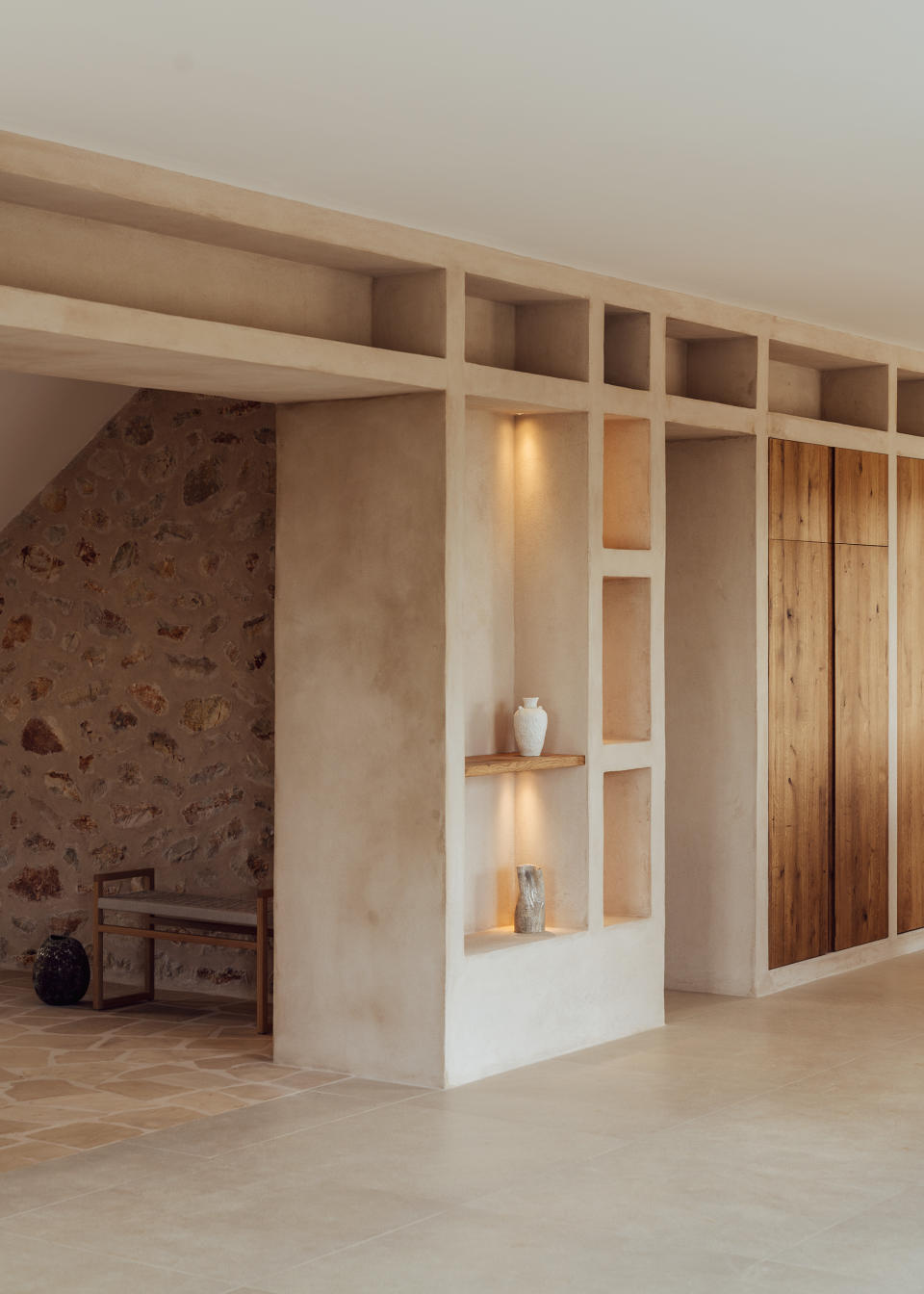 A passageway with recessed lights highlighting a cubby