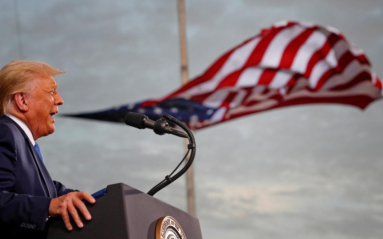 Campaign: President Donald Trump speaks, with a flag behind him, during a rally at Cecil Airport in Jacksonville, Florida, September 2020 - Tom Brenner/Reuters