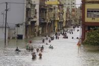 <p>Residentes vadean por una calle anegada en La Habana tras el paso del huracán Irma, en Cuba, el 10 de septiembre de 2017. El potente meteoro arrancó tejados, derribó edificios e inundó cientos de millas de territorio costero en Cuba tras dejar un rastro de destrucción en todo el Caribe. (AP Foto/Ramón Espinosa) </p>