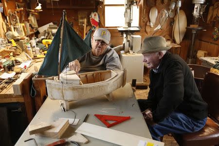 Lifetime Saxis Island resident Ellsworth Linton (R), 89, helps his friend Carroll Lee Marshall (L) build a model boat in Marshall's workshop in the neighboring village Sanford on Virginia's Eastern Shore October 25, 2013. REUTERS/Kevin Lamarque