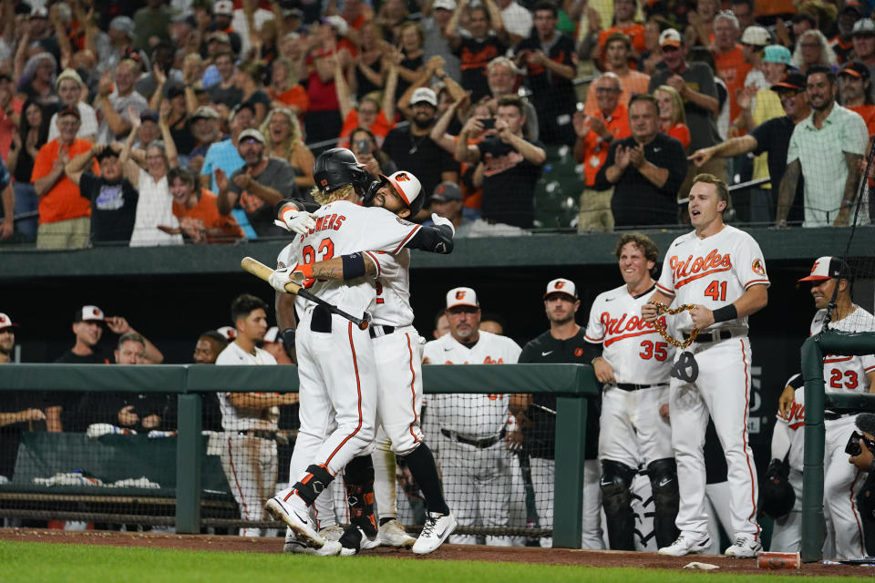 Baltimore Orioles' Kyle Stowers, left, is hugged by Rougned Odor after hitting his first career home run to tie the score 3-3 during the ninth inning of a baseball game against the Chicago White Sox, Thursday, Aug. 25, 2022, in Baltimore. The Orioles won 4-3 in 11 innings. (AP Photo/Julio Cortez)