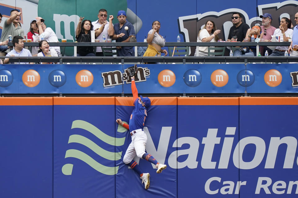 New York Mets center fielder Brandon Nimmo tries to make a catch on Washington Nationals' Juan Soto home run during the sixth inning of a baseball game, Sunday, Aug. 29, 2021, in New York. (AP Photo/Corey Sipkin)