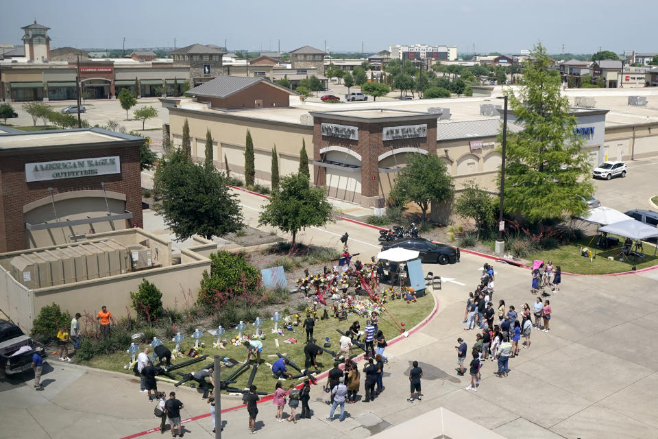 People gather around a makeshift memorial just outside of a mall where several people were killed in a mass shooting, Monday, May 8, 2023, in Allen, Texas. (AP Photo/Tony Gutierrez)