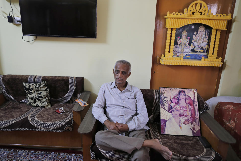 Radha Gobindo Pramanik sits by a portrait of his daughter on her wedding day, Thursday, June 3, 2021, in Lucknow, India. Two months ago Pramanik and his wife threw a party to celebrate their daughter's pregnancy and the upcoming birth of their long-awaited grandchild. They were so happy that they paid little attention to his wife's cough. Within days, his wife, his daughter and his unborn grandchild were all dead, among the tens of thousands killed as the coronavirus ravaged India in April and May. (AP Photo/Rajesh Kumar Singh)