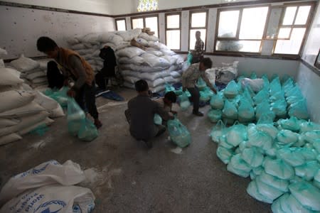 Worker weighs the aid provided by the World Food Programme (WFP) for distribution in Sanaa