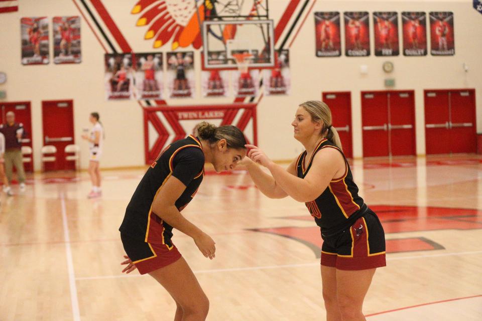 McCutcheon freshman Lillie Graves (left) gets crowned by her junior teammate Mallorie Beutel (right) during pregame announcements of the Twin Lakes Holiday Tournament on Wednesday, Dec. 27, 2023.