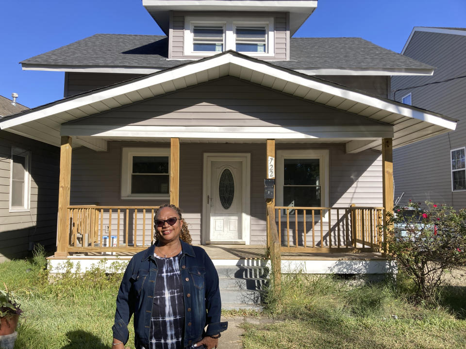 Karen Speights stands outside of her 1920s craftsman house in Norfolk, Va., Friday Oct. 7, 2022. A contractor had replaced the historic home’s original pine floor after a flood and installed laminate flooring. (AP Photo/Ben Finley)