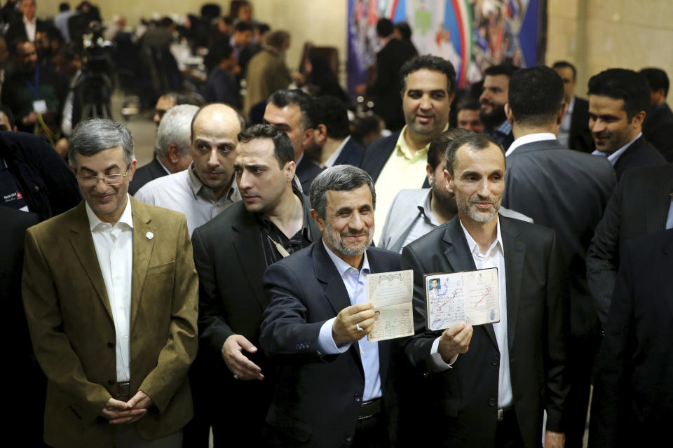 Former Iranian President Mahmoud Ahmadinejad, center, and his close ally Hamid Baghaei, right, show their identifications after registering their candidacy for the upcoming presidential elections at the Interior Ministry to , in Tehran, Iran, Wednesday, April 12, 2017. Ahmadinejad on Wednesday unexpectedly filed to run in the country's May presidential election, contradicting a recommendation from the supreme leader to stay out of the race. Other close ally of Ahmadinejad, Esfandiar Rahim Mashie accompanies them. (AP Photo/Ebrahim Noroozi)