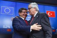 Turkish Prime Minister Ahmet Davutoglu (L) and European Commission President Jean Claude Juncker (R) greet each other after a news conference following a EU-Turkey summit in Brussels, Belgium November 29, 2015. REUTERS/Yves Herman