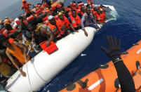 FILE PHOTO: Migrants on a dinghy are rescued by "Save the Children" NGO crew from the ship Vos Hestia in the Mediterranean sea off Libya coast, June 17, 2017. REUTERS/Stefano Rellandini/File Photo