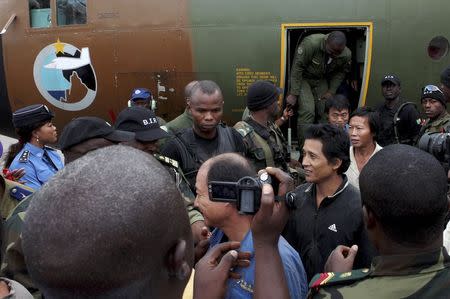 Cameroonian military personnel watch as freed hostages disembark from a military plane upon arriving at the Nsimalen International Airport in Yaounde November 26, 2014. REUTERS/Stringer