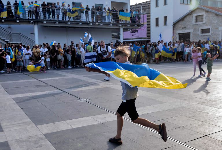 Un ni&#xf1;o corre con una bandera nacional ucraniana durante una manifestaci&#xf3;n en solidaridad con Ucrania en la ciudad portuaria de Limassol, al sur de Chipre, mientras los europeos conmemoran la victoria aliada contra la Alemania nazi y el fin de la Segunda Guerra Mundial en Europa (D&#xed;a de la Victoria), el 8 de mayo de 2022.