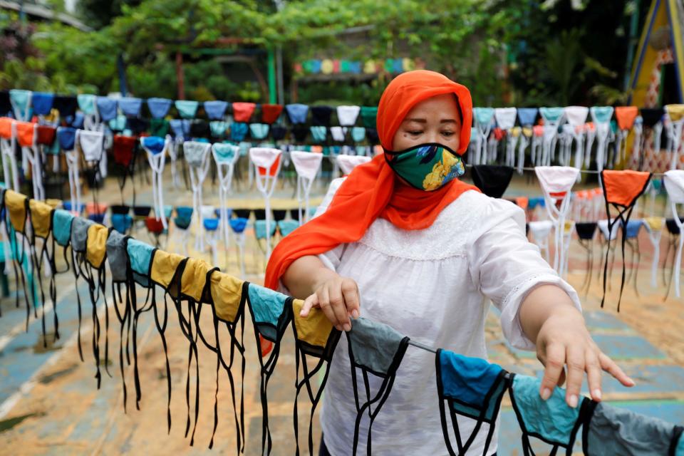 A woman puts cloth face masks on a string to dry before distributing it for free around the neighbourhood, amid the spread of coronavirus, in Tangerang, on the outskirts of Jakarta, on April 9.