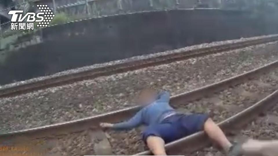 林男躺在鐵軌上睡覺。（圖／TVBS）
