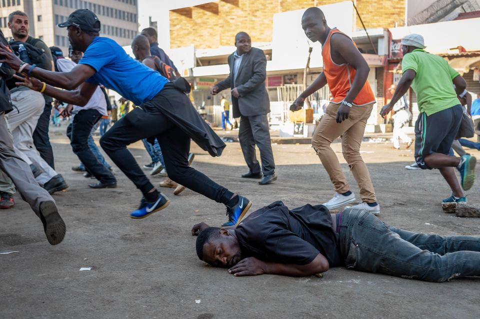 <p>A man who was shot in the back by a live round fired by the Zimbabwean Army lies on the ground bleeding during a protest against the vote count in Harare, Zimbabwe, 01 August 2018. The Zimbabwean army refused to allow journalists to treat the man and attempted to arrest them. (Photo: Yeshiel Panchia/EPA-EFE/REX/Shutterstock) </p>