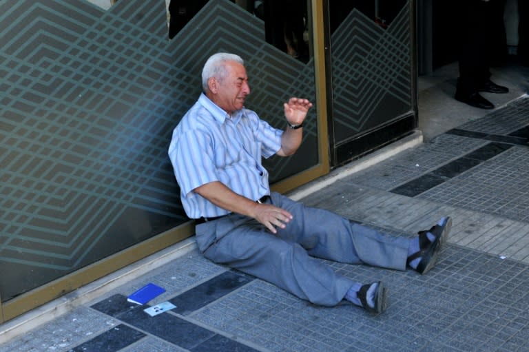 Greek pensioner, Giorgos Chatzifotiadis, cries as he sits on the ground outside a national bank branch in Thessaloniki on July 3, 2015