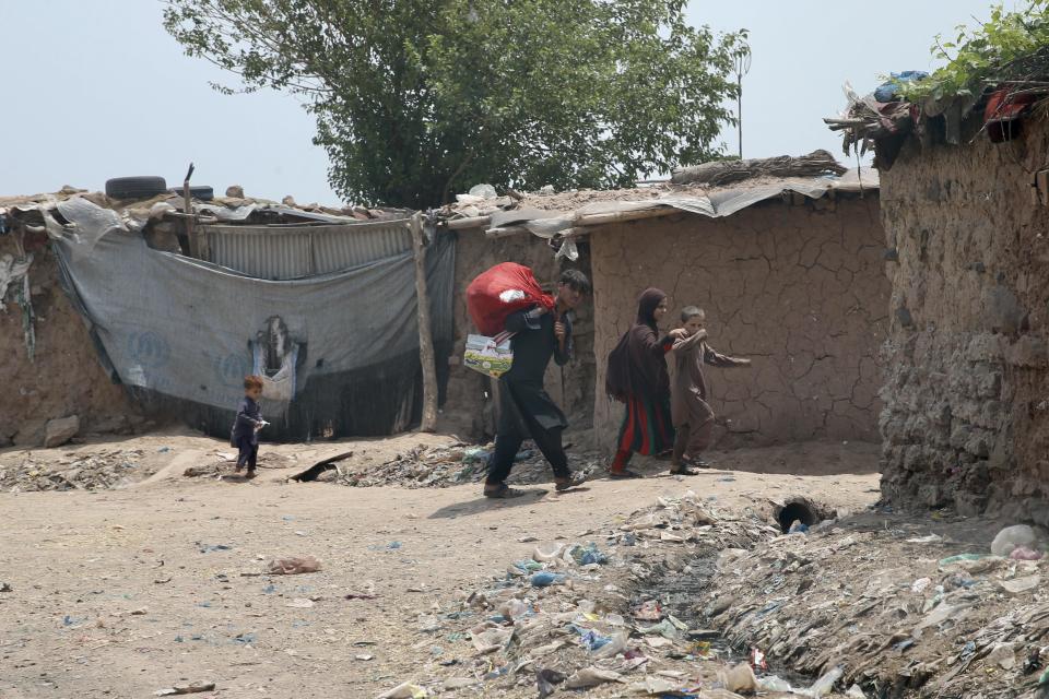Children walk by makeshift houses in a side street as Afghan refugees are struggling to survive under difficult conditions in Islamabad, Pakistan on May 29, 2022. / Credit: Muhammed Semih Ugurlu/Anadolu Agency via Getty Images