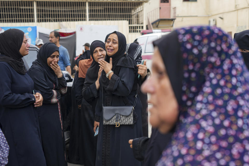 Palestinians mourn the three civil defense members killed in the Israeli bombardment of Nuseirat refugee camp, at al-Aqsa Martyrs Hospital in Deir al Balah, central Gaza Strip, Friday, June 28, 2024. (AP Photo/Abdel Kareem Hana)