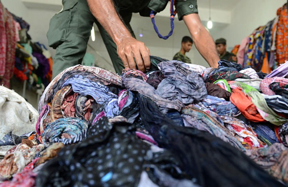 Army personnel clean a flood-damaged shop