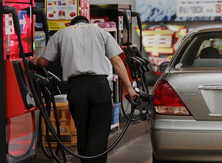 A gas station worker fuels a vehicle in Tokyo August 26, 2015. REUTERS/Toru Hanai/Files