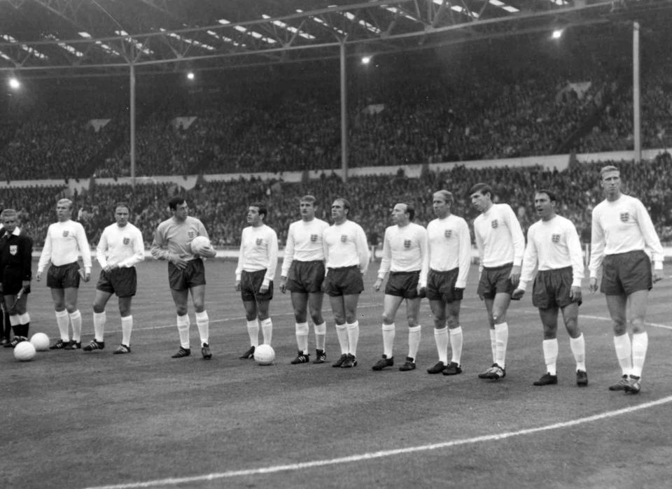 FILE - In this July 20, 1966 file photo, England line-up before their soccer World Cup match against France, at Wembley Stadium, London, from second left. Bobby Moore, George Cohen, Gordon Banks, Ian Callaghan, Roger Hunt, Ramon Wilson, Nobby Stiles, Bobby Charlton, Martin Peters, Jimmy Greaves and Jackie Charlton. Jimmy Greaves, one of England’s greatest goal-scorers who was prolific for Tottenham, Chelsea and AC Milan has died. He was 81. With 266 goals in 379 appearances, Greaves was the all-time record scorer for Tottenham, which announced his death on Sunday, Sept. 19, 2021. (Bippa via AP, File)