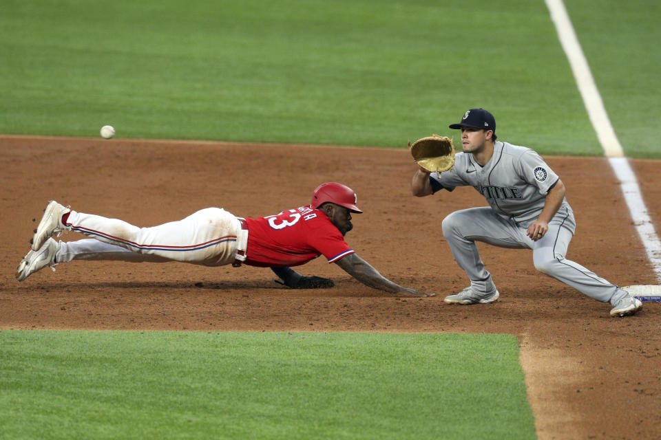 Texas Rangers' Adolis Garcia (53) dives back to first as Seattle Mariners first baseman Evan White (12) gets the pickoff throw during the third inning during a baseball game Friday, May 7, 2021, in Arlington, Texas. Garcia was initially called safe but after review was called out. (AP Photo/Richard W. Rodriguez)