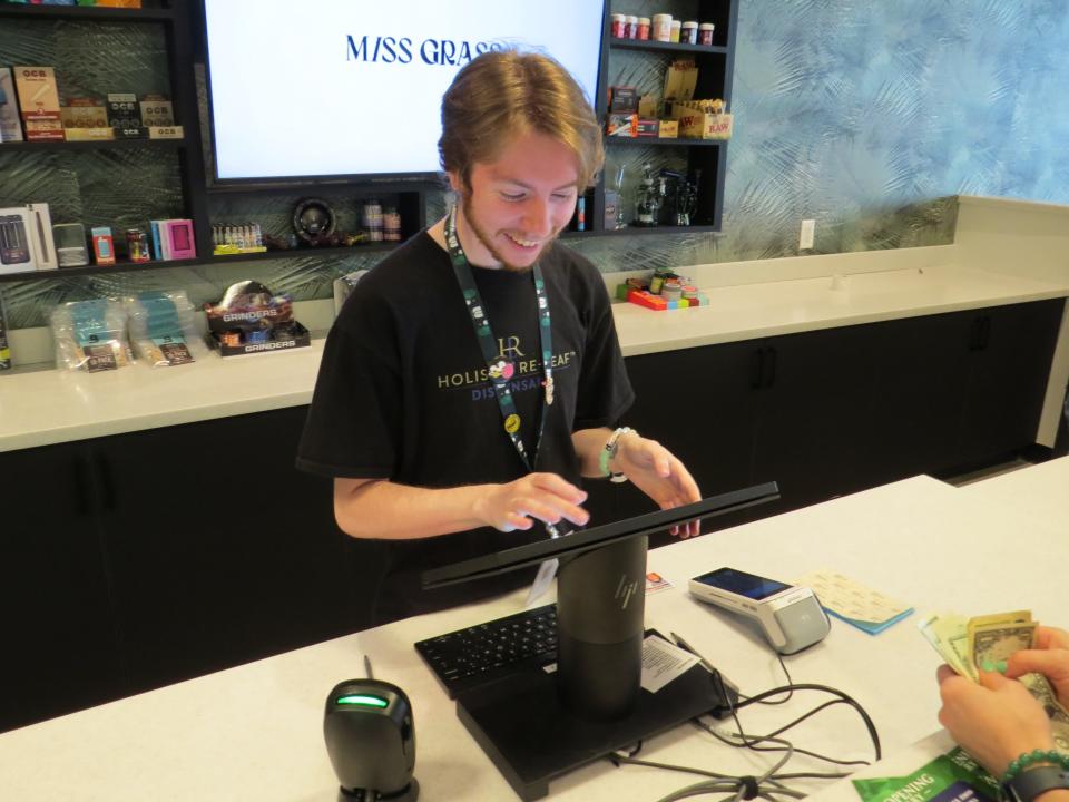 A 'bud-tender" rings up a sale during the grand opening of Holistic Re-Leaf, Morris County's second retail recreational cannabis dispensary on March 15, 2024 at a shopping strip outside the Rockaway Townsquare mall complex.