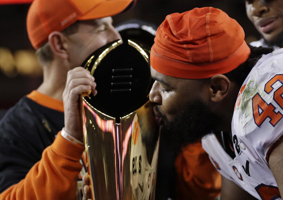 Clemson defensive lineman Christian Wilkins kisses the trophy after winning the championship Monday night. (Photo: ASSOCIATED PRESS)