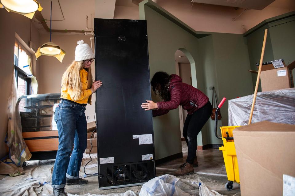 Nina Forsyth and Hannah Norris move a cooler to its new spot at Arboretum Coffee in Fort Collins on Friday.